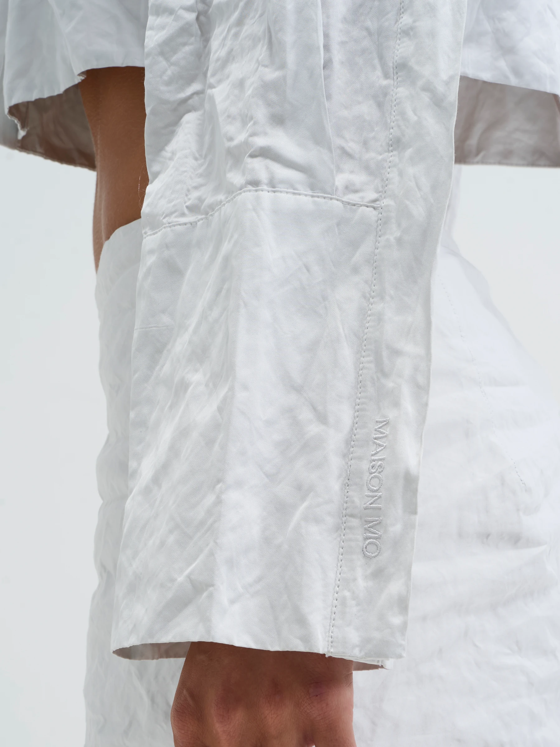 White cropped shirt in Palimpsest, detail showing white cropped shirt sleeve