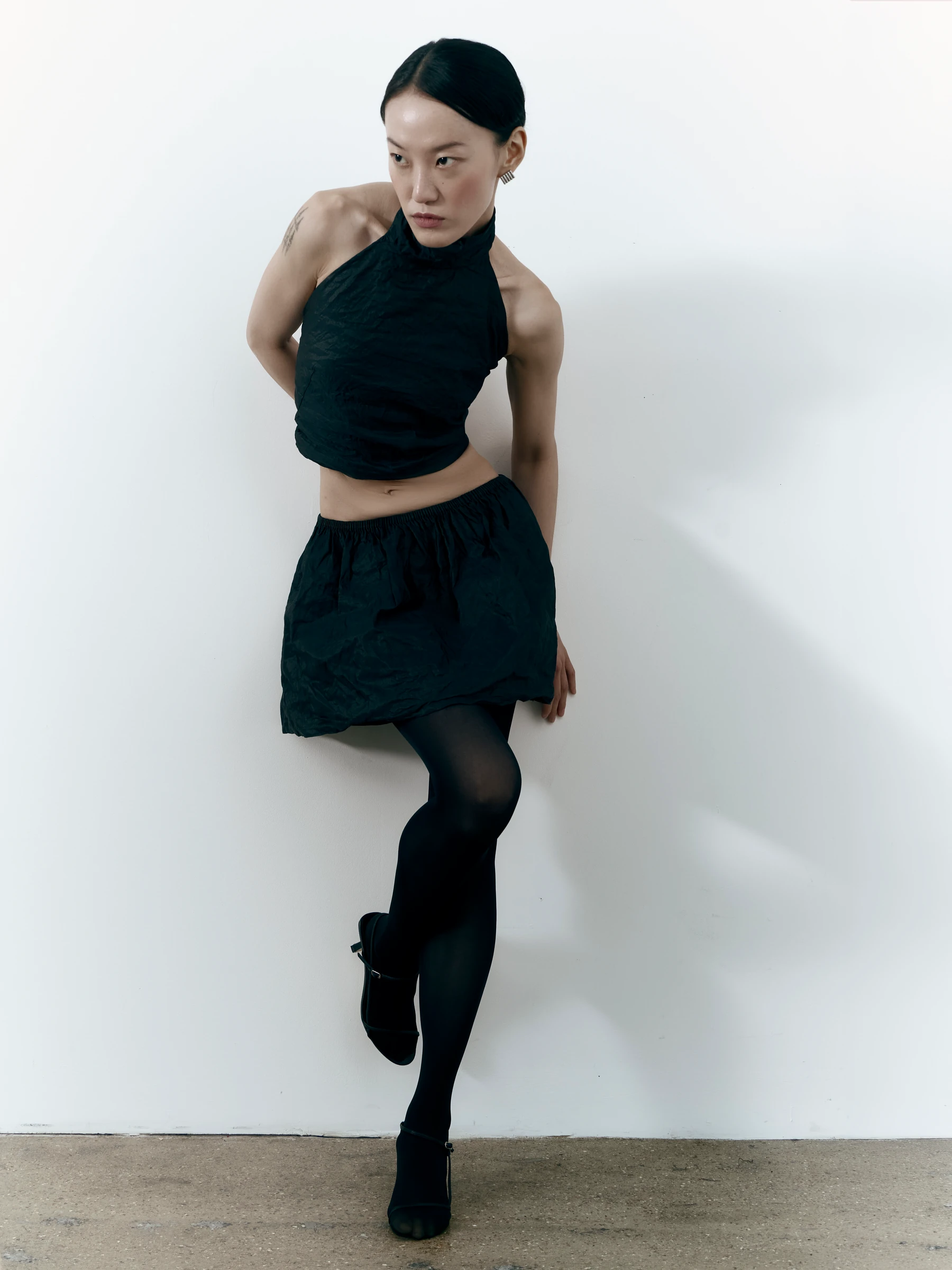Black halter top in Carbon crease, three-quarter view