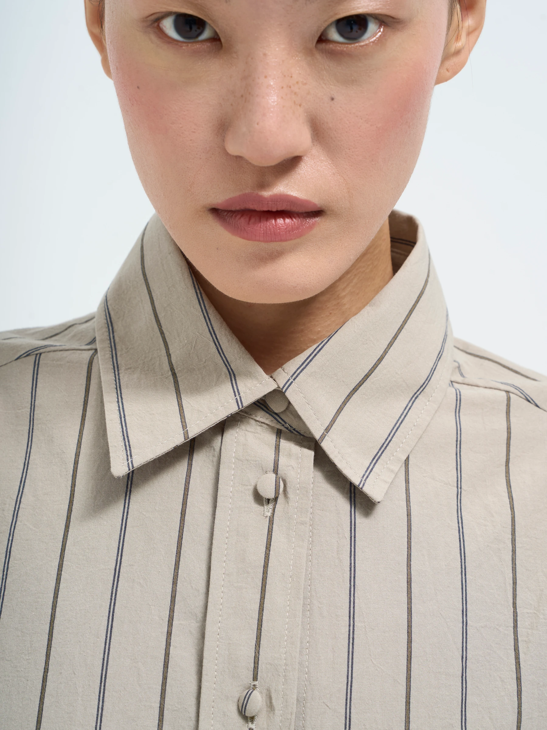 Beige striped shirt in Nicotine, detail showing beige striped button-up shirt
