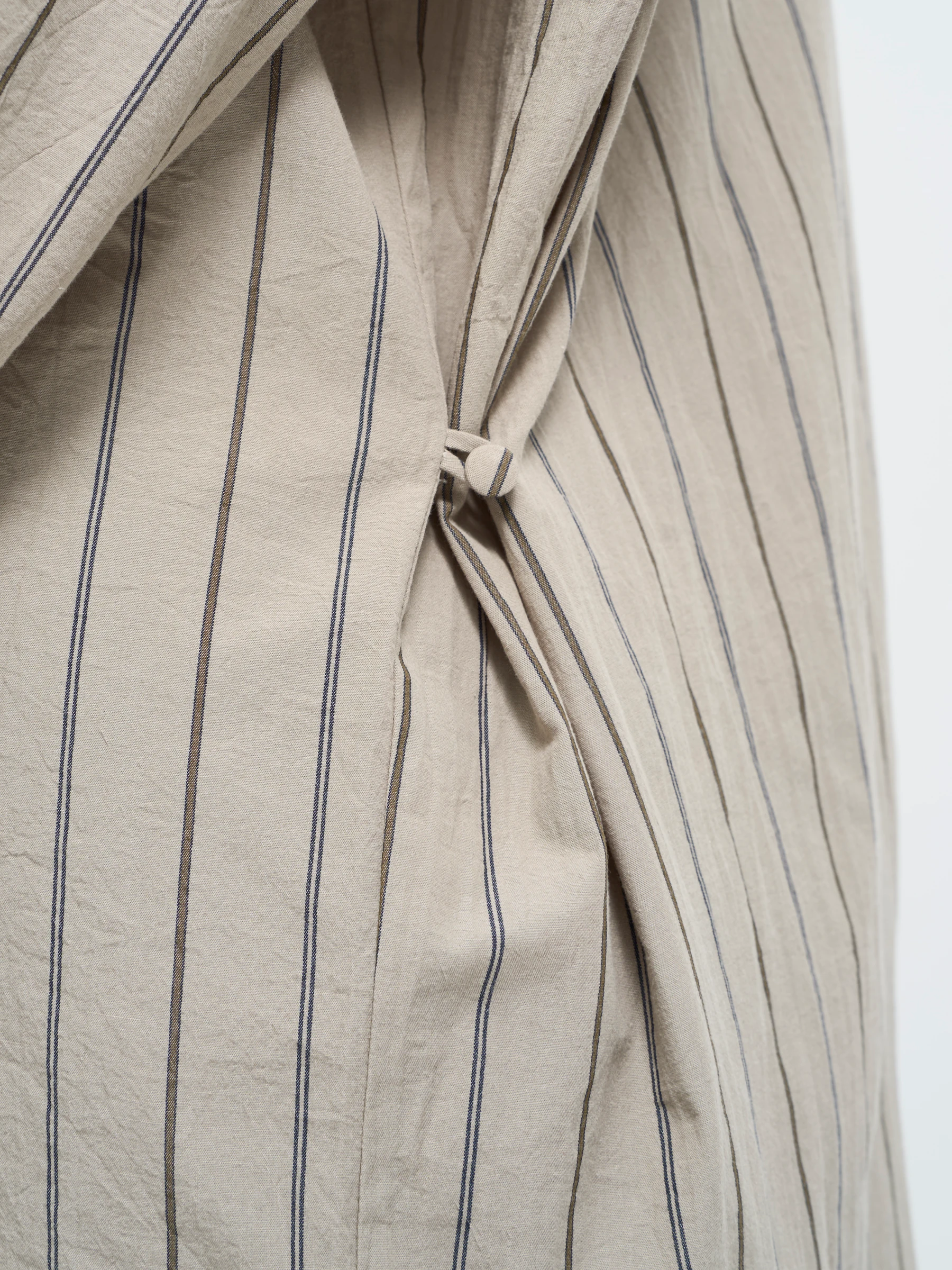 Beige striped shirt in Nicotine, detail showing striped shirt hem knot