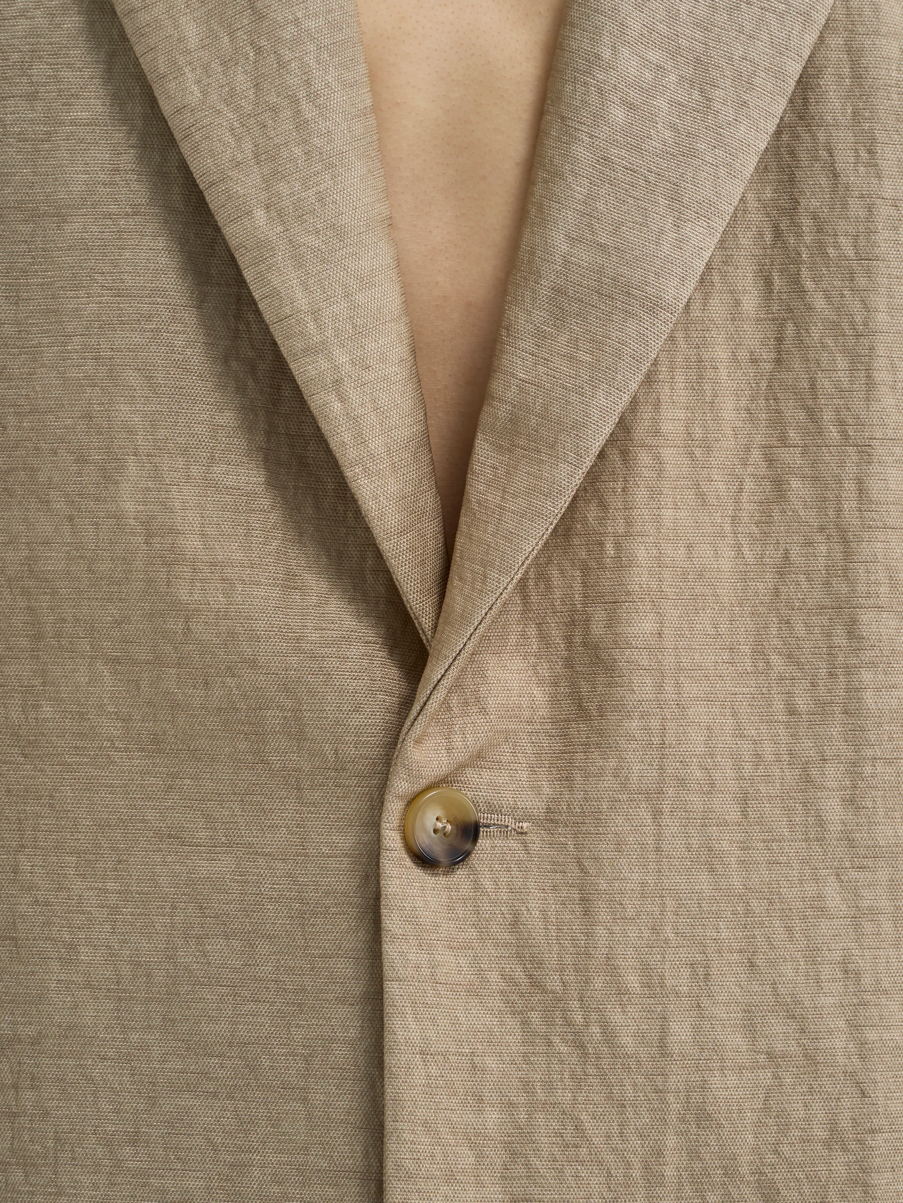 Beige backless blazer in Foxing, detail showing blazer collar and button